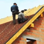 construction workers on a house roof