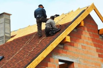 construction workers on a house roof