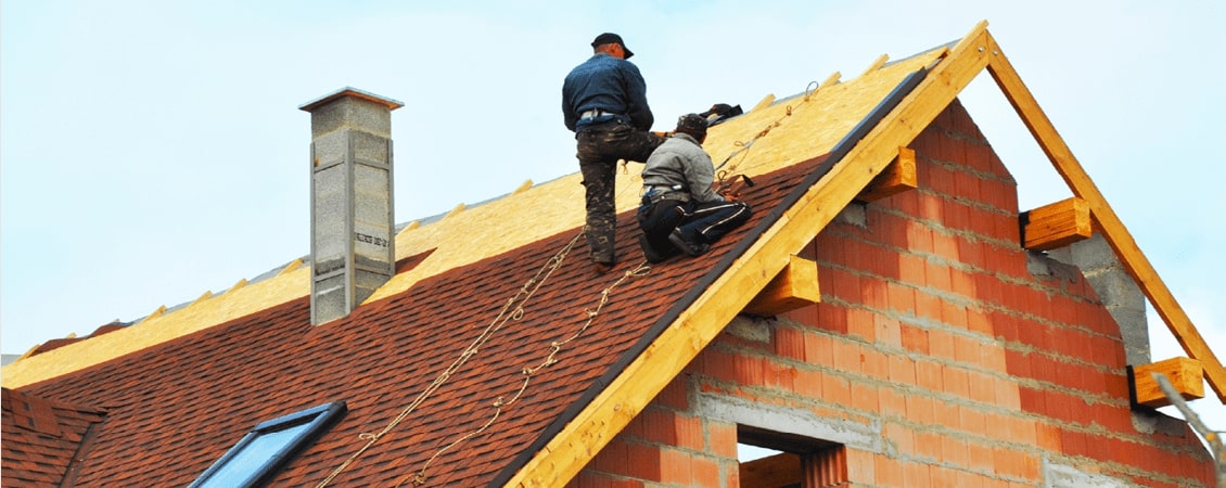 construction workers on a house roof